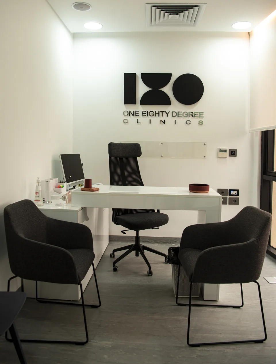 A consultation room with the 180° logo on the wall