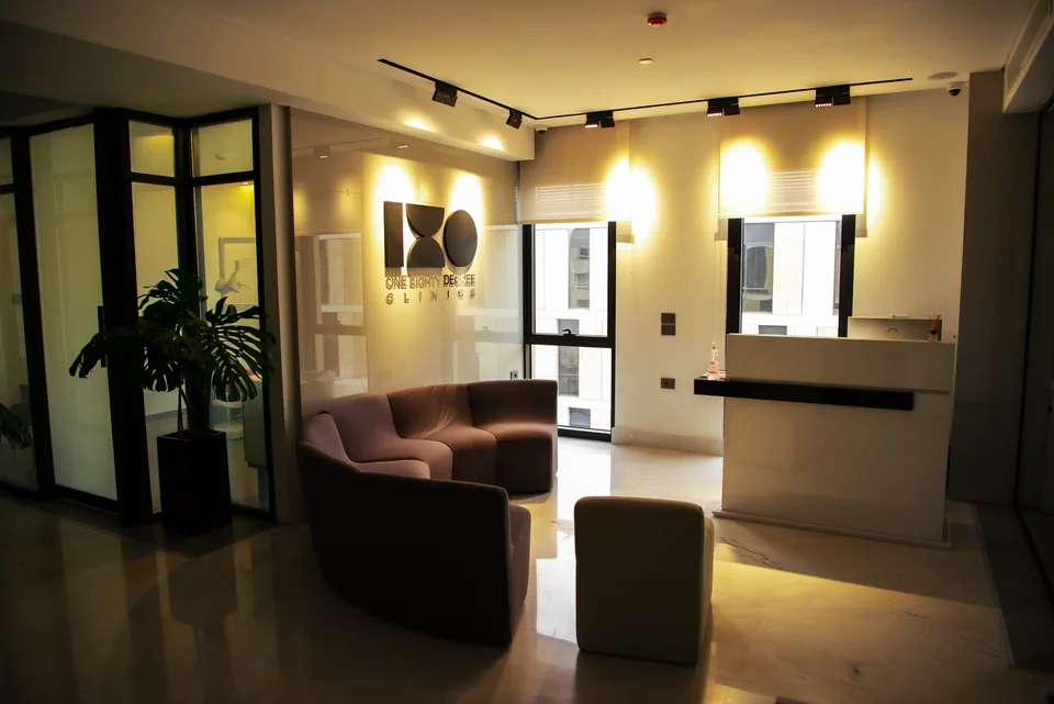 The 180° reception, with the clinic's own wall logo and warm seating